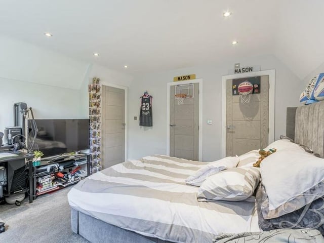 This busy bedroom on the first floor looks ideal for a teenager. It features downlights, a carpeted floor and space for a desk.