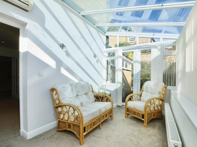 This versatile sun room can be used as a snug or a sitting room, with air-conditioning making it a comfortable space. French doors lead to the back garden.
