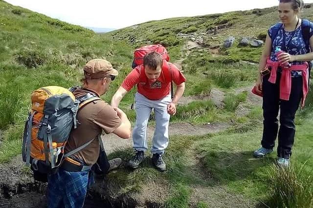 One of the young 'adventurers' being helped by an instructor on a break in the Peak District.