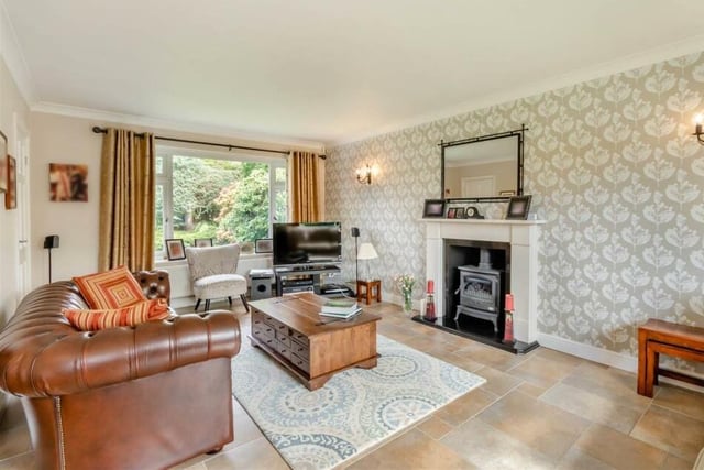 The living room features a superb limestone fireplace with an inset log-burner-style gas fire and granite hearth.