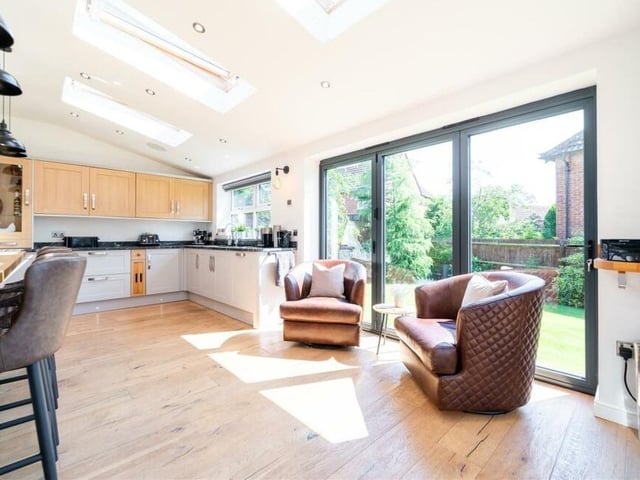 Part of the open-plan kitchen is a cosy family living space in front of bi-folding doors that lead to the rear garden and its sheltered terrace.