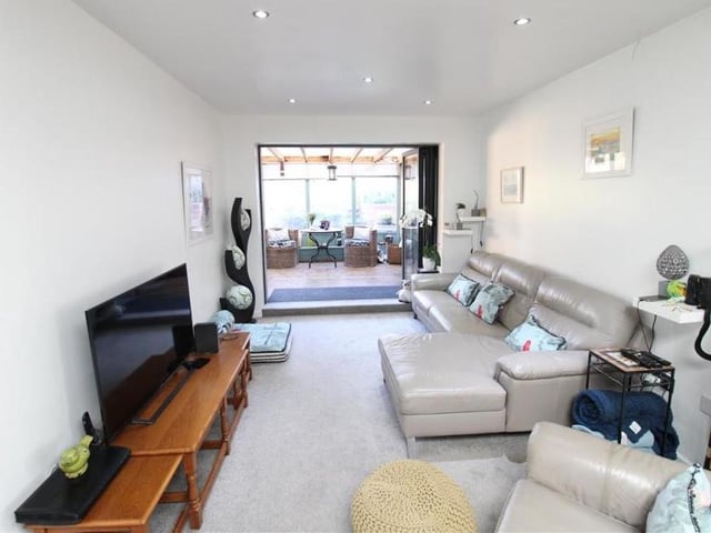 The first room we turn to on our tour of the Eastwood bungalow is this relaxing lounge, which has open-plan access to the kitchen and also doors leading to the dining room. Spotlights to the ceiling add a touch of class.