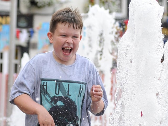 Joshua Molloy, ten, from Mansfield, takes some time off the beach to play in the water attraction on the Market Place.