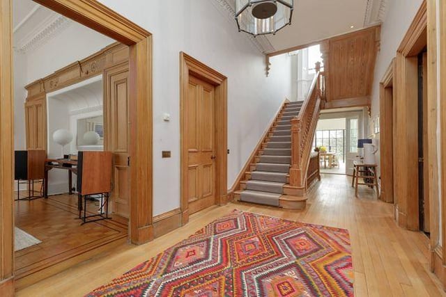 A solid oak staircase sits in an airy and light hallway, also oak panelled.