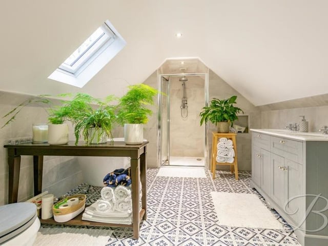 The master bedroom also boasts this en suite bathroom, a lavish four-piece suite that is perfect for unwinding. It comprises a free-standing bath, walk-in shower cubicle, double hand wash vanity unit and low-flush WC. There's also sensor lighting, underfloor heating and a Velux window.