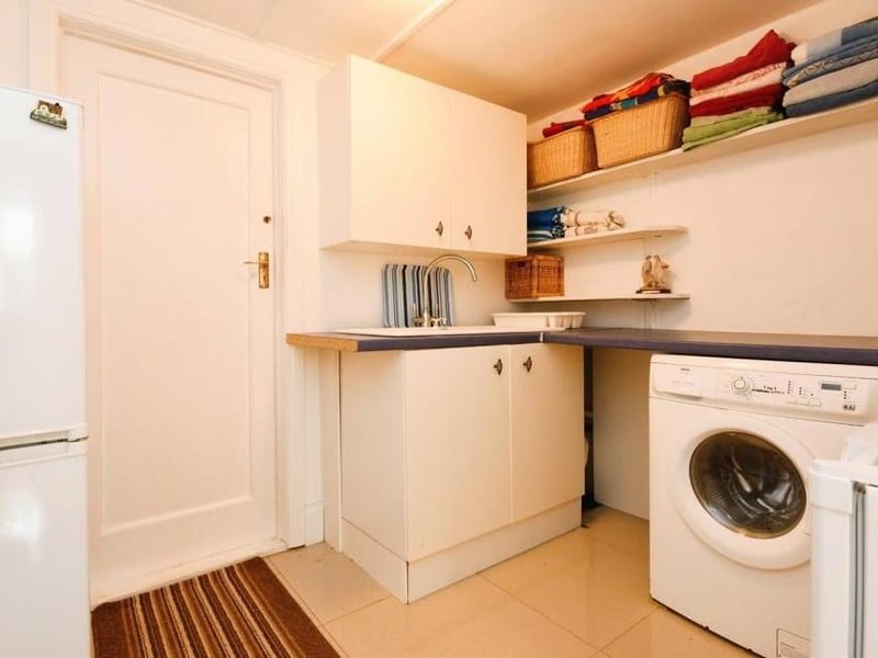 A door from the kitchen leads to this handy utility room, which has units, a roll-edged work surface and sink and drainer. There is also space for a washing machine and fridge freezer, while doors guide you to both a WC and the garage.