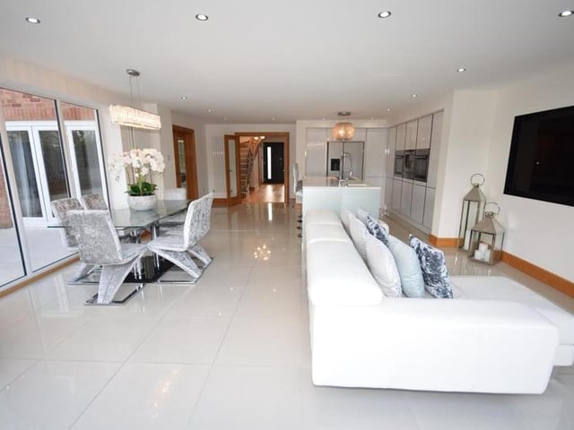 This image shows perfectly how the kitchen section opens out to form a sociable living space. It includes a large dining area with a view, plus a family-friendly seating area.