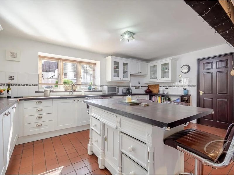 A spacious kitchen is the heart of the home featuring striking traditional wooden ceiling beams that add character and warmth to the room.