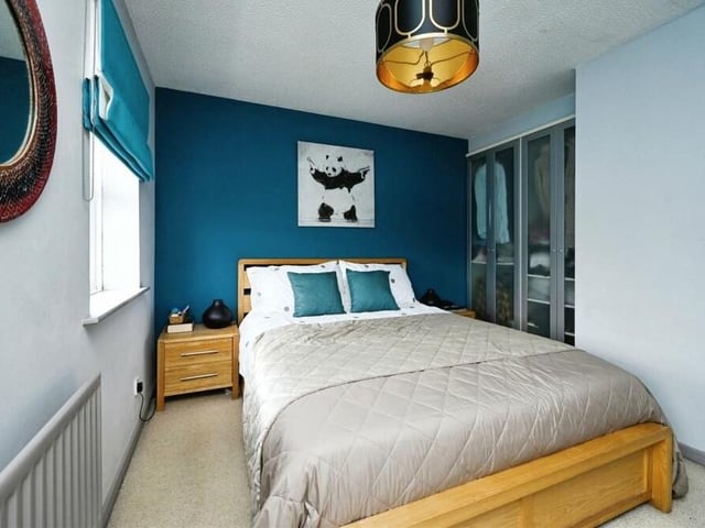 The main bedroom on the first floor has two double doors leading to built-in wardrobes and a door to a built-in storage cupboard.