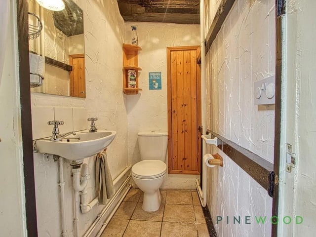 This cloakroom offers a compact and functional space with tiled flooring and simple white walls