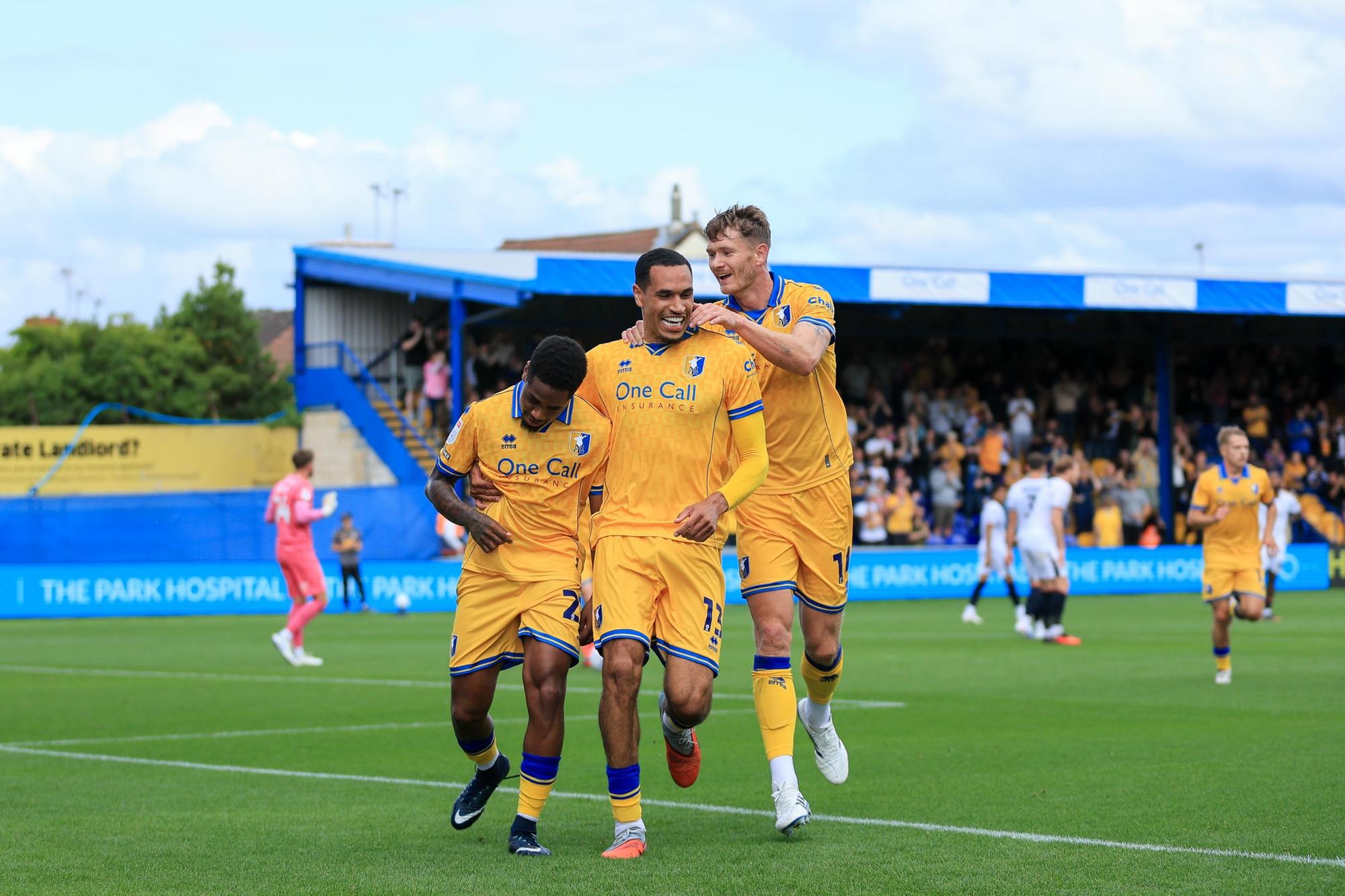 Nathan Moriah-Welsh celebrates his 1st half goal with Jon Russell and Michael Smith during the Sky Bet League 1 match against Luton Town FC at the One Call Stadium, 30 Aug 2026, Photo credit Chris & Jeanette Holloway / The Bigger Picture.media