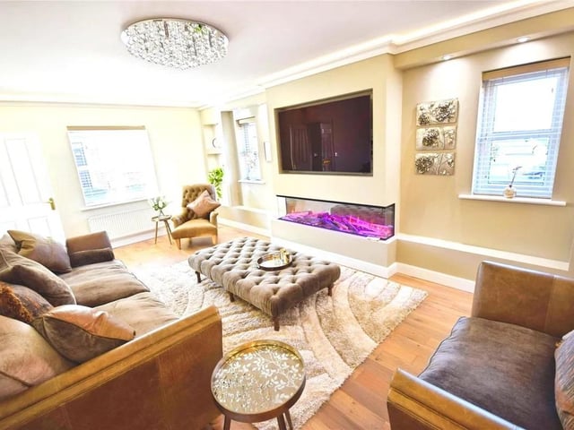 A welcoming room with feature media wall & fire, two upvc double glazed windows to the side & one to the front, solid oak flooring.