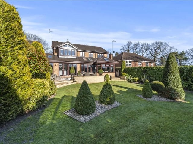 The majority of the garden being laid to lawn, with hedge row boundaries, feature trees, shrubs and bushes throughout and a garden shed.