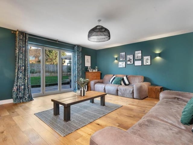 The lovely lounge from a different angle, showing its ambient, up-and-down wall-lighting and oak flooring.
