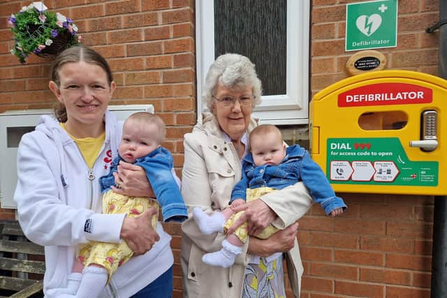 Mike’s daughter Sharleen and widow Sylvia, with twins Olivia and Sophia, with the new defibrillator. Photo: Submitted