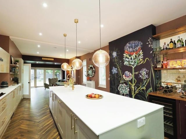 Next stop is this stunning, open-plan kitchen diner, which is fitted with a range of wall and base units and boasts a central island with Dekton work surface. Can you also spot a small bar area?