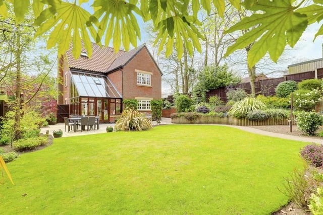 Stepping outside now and what a beautiful sight the private, landscaped back garden makes. It features multiple patio areas, a lawn and a range of decorative plants and shrubs, mature trees and raised planters