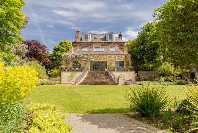 View of the house from the back garden, with a sweeping, stone, staircase to the house.