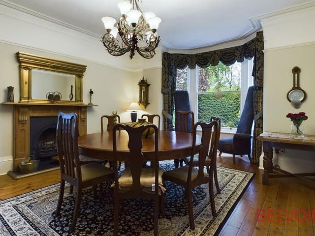 On now to the delectable dining room, which is distinguished by its large bay window, log-effect gas fire with wooden surround, chandelier, natural wood flooring and cast-iron radiator.