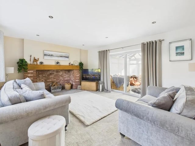 Elegant and cosy lounge with a stunning feature brick open fireplace with oak mantle and stone hearth. Dual aspect windows allow light to flood into this lovely space with patio doors leading into the conservatory.