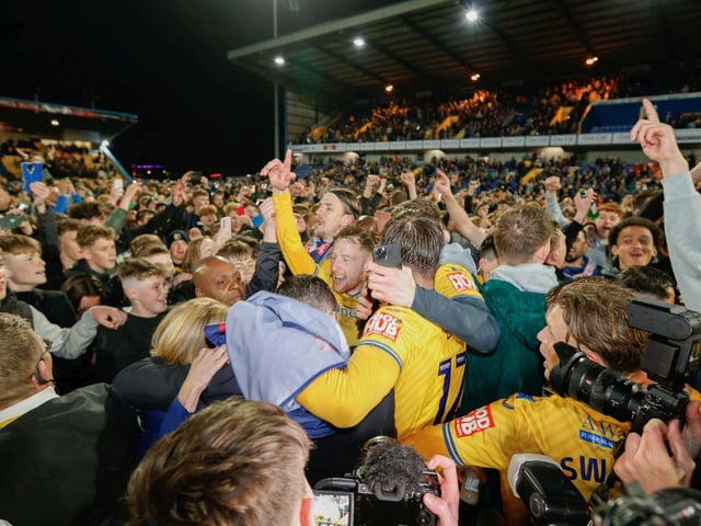 Players celebrate with fans after promotion is clinched at home to Accrington in April.