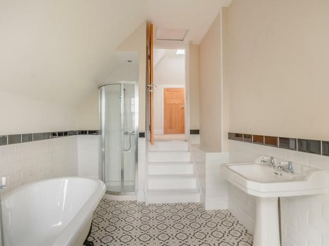 The family bathroom also features a cosy shower cubicle, a tile-effect vinyl floor, partly-tiled walls and a loft hatch.