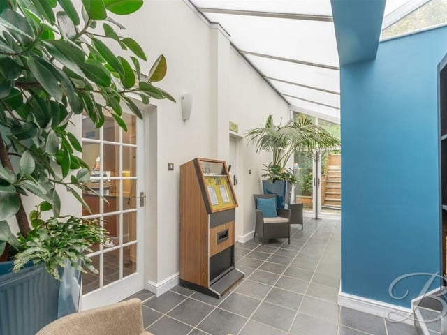 A second look at the bright conservatory, with its tiled flooring and French doors at the far end providing access to the back garden.