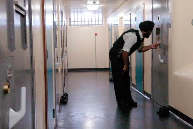 An officer checks the cells at a police station.