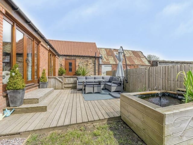 Stepping outside, here is the high spot of the large garden, which surrounds the £425,000-plus property -- decking with a seating area, ideal for al fresco entertaining when the weather suits.
