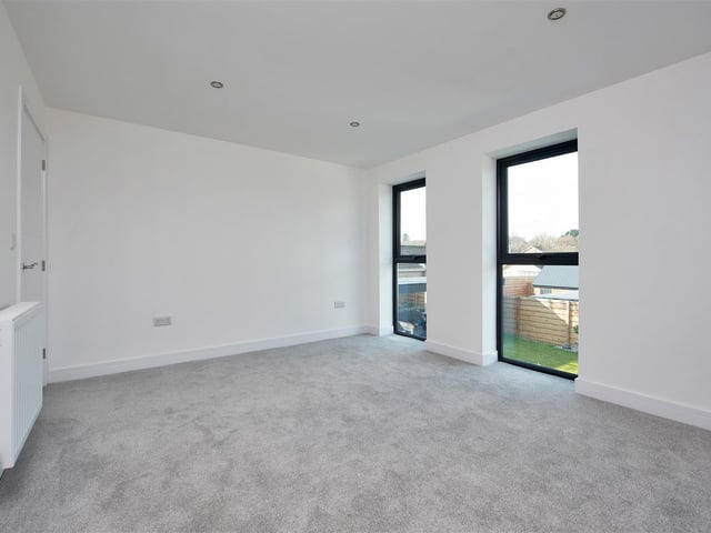 With radiator, four ceiling spotlights and two, floor-to-ceiling, double-glazed windows to the rear elevation.