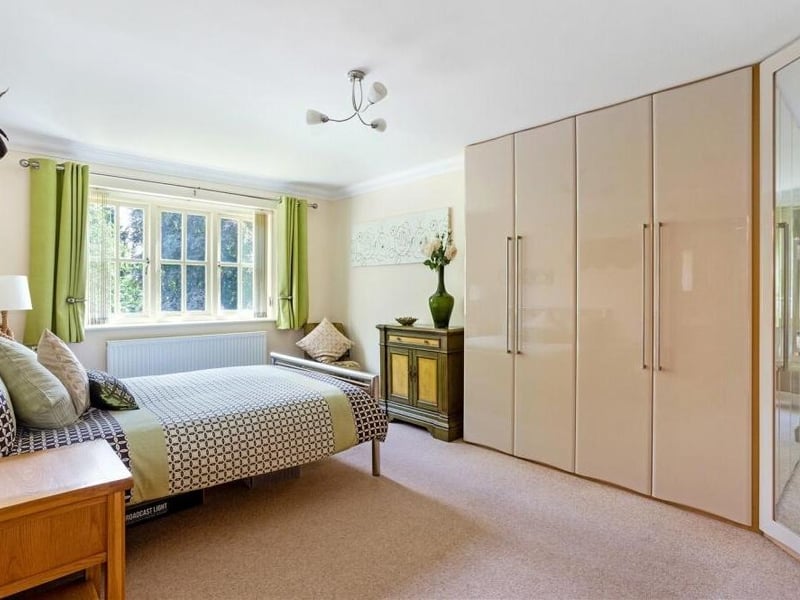 All five bedrooms can be found on the first floor, with this one offering terrific views of the front garden. It is fitted with high-gloss, putty-coloured wardrobes, one of which is mirror-fronted. It has access to an en suite shower room.