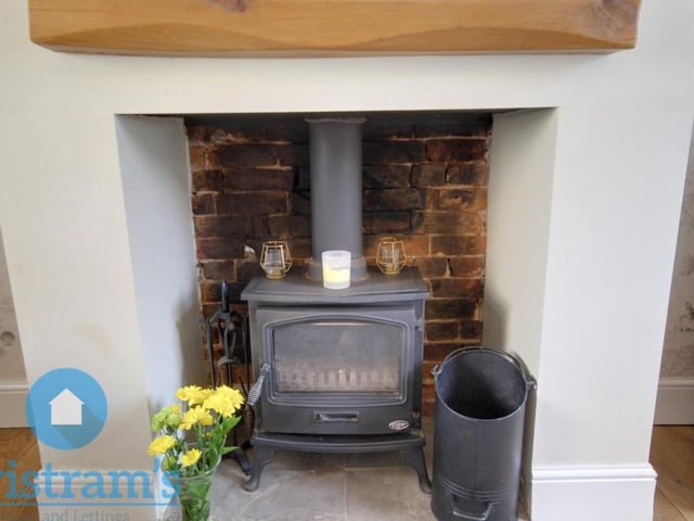 The character of the living room is enhanced considerably by this fitted log-burner.