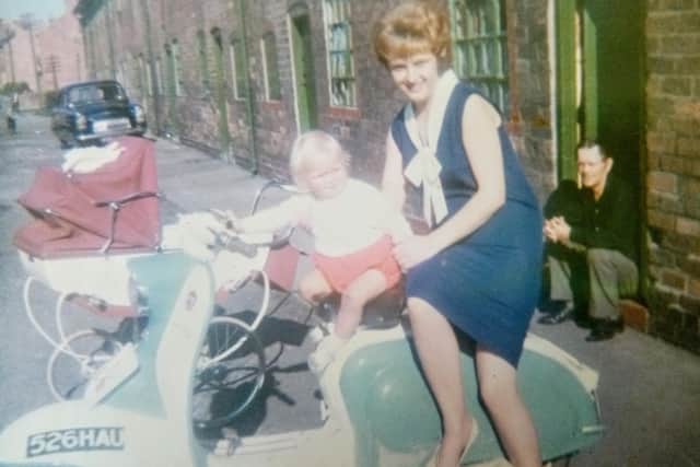 Alfred is seen sitting on the step in the background while his daughter Julie and grandson Russell are pictured on the motorbike