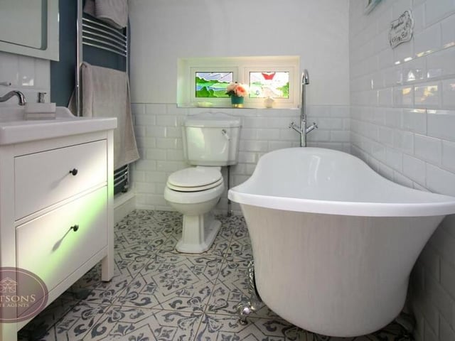 Here is the family bathroom, which consists of a three-piece suite in white. A free-standing roll-top bath is complemented by a vanity sink unit and WC. There is also a chrome, heated towel-rail.