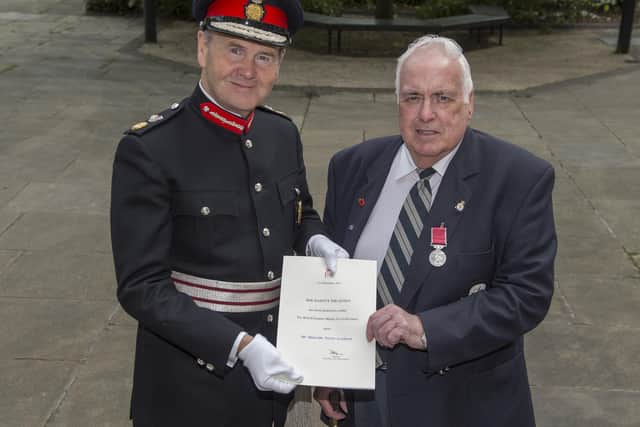 Malcolm Scothern (right) receives the British Empire Medal in 2016 from Sir John Peace, Lord-Lieutenant of Nottinghamshire.