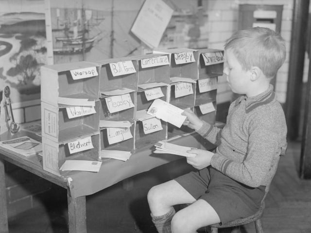 A young letter sorter at work at King Edward Infants School's miniature post office in 1935.