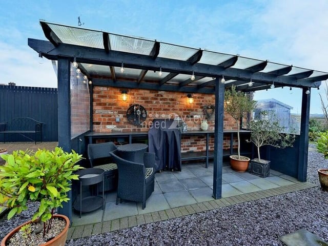 A fascinating feature of the back garden is this covered seating area, which is suitable for most kinds of weather.