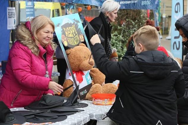Volunteers hand out witches hats in the Market Place for Halloween