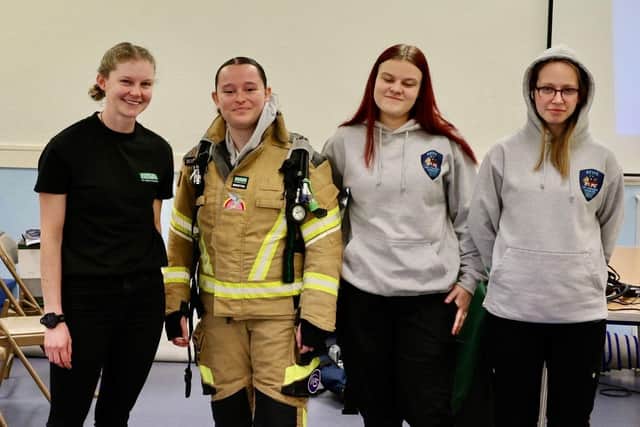 NFRS Crew Manager Lou Needham (L) with learners who tried on firefighters kit and breathing apparatus.