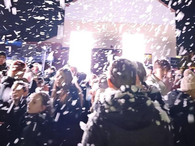 Crowds are doused in 'snow' as the lights are switched on.