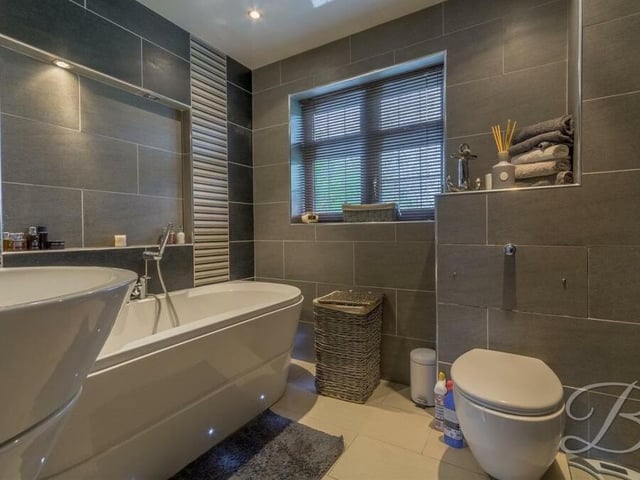The family bathroom on the first floor is a real eyecatcher. A modern three-piece suite comprises a free-standing bath, wash hand basin, WC and a TV that is also a mirror.