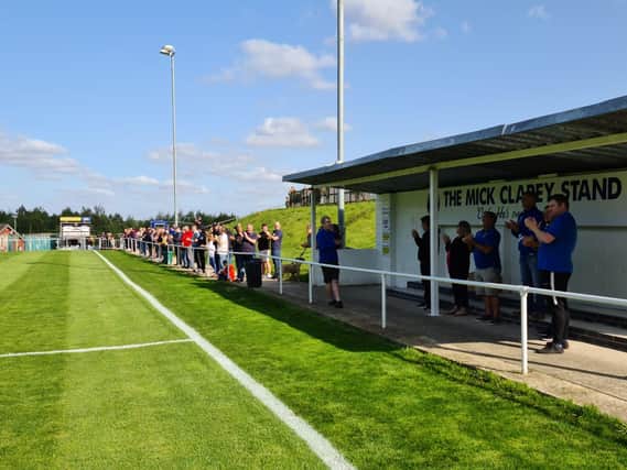 Fans pay tribute to former Sherwood Colliery club volunteer Mick Clarey in front of the newly renamed stand.