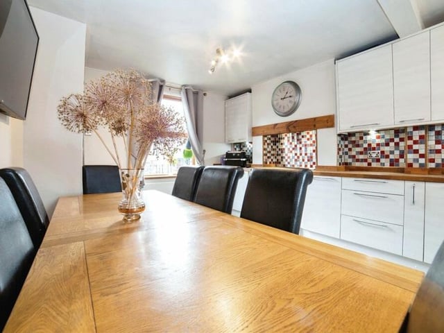 The kitchen has plenty of space for a dining table. There is also a single drainer sink unit with mixer taps, a tiled floor, splashbacks and windows to the front and back of the house. A nearby utility room has space for a washing machine.