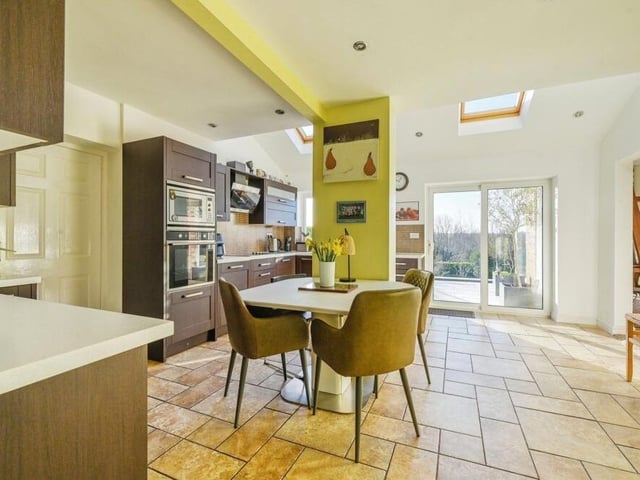 Let's begin our brief tour of the £450,000 Kirkby property in the large open-plan kitchen diner, which helps to form the rear extension that has added so much to the house. Integrated appliances include an electric oven, microwave, dishwasher and electric hob with hood above, all blending in to the substantial storage and worktop space. Tiled flooring, underfloor heating, spotlights and patio doors leading to the back garden all inject style, while there is plenty of space for a breakfast/dining table.