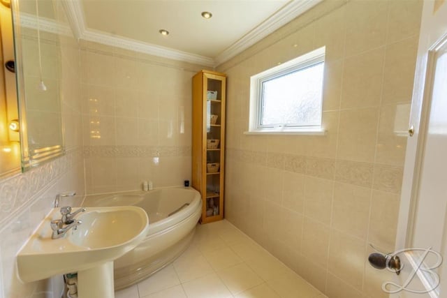 At the top of the stairs, the landing gives access to three of the four bedrooms. But before we look at those, let's check out the family bathroom, which is very well presented. You have to love the corner, wall-mounted bath-tub suite.
