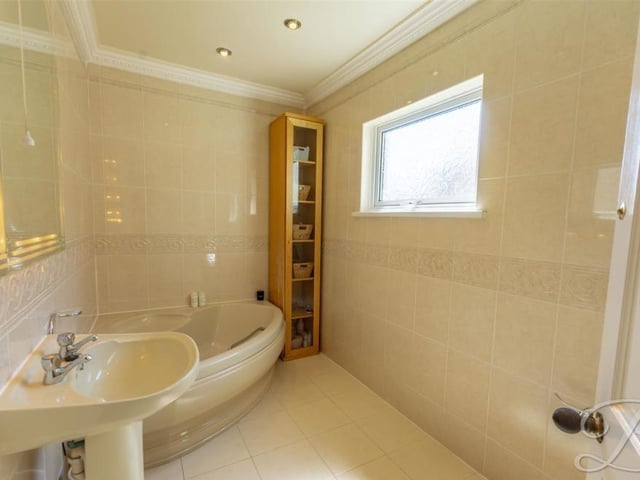 At the top of the stairs, the landing gives access to three of the four bedrooms. But before we look at those, let's check out the family bathroom, which is very well presented. You have to love the corner, wall-mounted bath-tub suite.