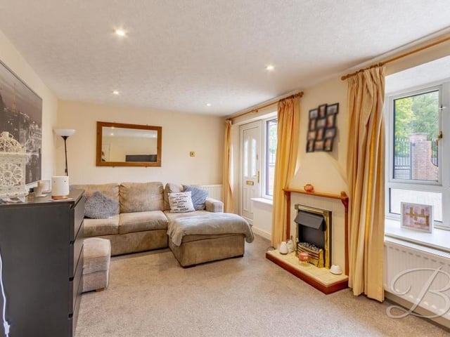 Staying in the annexe, this is its living room, with a feature fireplace, carpeted floor and downlights. Double windows facing the front of the house make it bright and welcoming.