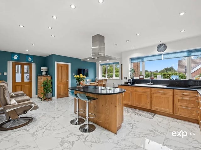 An attractive and extended detached bungalow, set in a sought-after location, featuring the ease of single-level living. This beautifully presented home features flexible, light-filled interiors, including a vast open-plan living, dining, kitchen. The luxury kitchen is fitted with banks of solid oak bespoke wall and base units that offer plenty of storage with a complementing granite worktop inset with a ceramic sink and drainer, incorporating an integrated dishwasher beneath. The main attraction is the on-trend central island that works as a breakfast bar for informal kitchen dining. It is inset with a Miele four-ring induction hob with extractor above. Additional quality appliances include a Miele oven and a complementing Miele microwave/grill and warmer, plus a tall fridge/freezer with a secondary freezer.