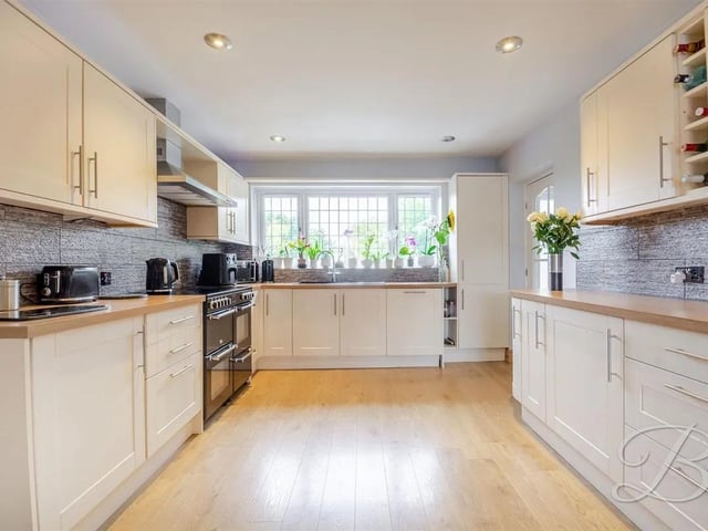 The kitchen is both stylish and practical, fitted with a range of matching cabinetry and ample worktop surfaces to provide plenty of preparation and storage space. A window to the rear elevation fills the room with natural light, while double doors open seamlessly into the dining room, creating a great flow for family meals and entertaining.