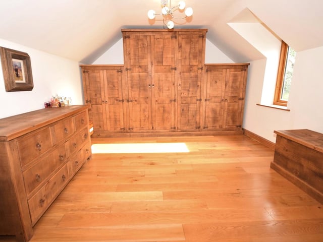The third double bedroom on the first floor of the £925,000 property is currently being used as a dressing room. It is distinguished by its wardrobe and storage space, and solid oak floor.
